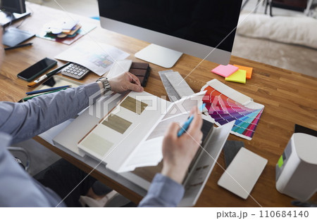 Interior designer create color mix for new house project, palette on workplace in agency Interior designer create color mix for new house project, palette on workplace in agency 110684140