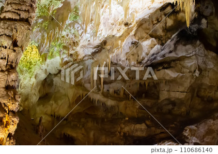 The cave is karst, amazing view of stalactites and stalagnites illuminated by bright light, a beautiful natural attraction in a tourist place. The cave is karst, amazing view of stalactites and stalagnites illuminated by bright light, a beautiful natural attraction in a tourist place. 110686140
