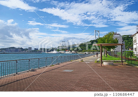 北九州市門司区のめかり観潮遊歩道を歩く人と関門橋 北九州市門司区のめかり観潮遊歩道を歩く人と関門橋 110686447