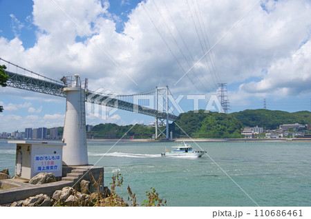 福岡県北九州市門司区の関門海峡に架かる関門橋と門司埼灯台 110686461