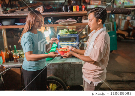 female customer receiving bowl of noodle female customer receiving bowl of noodle 110689092