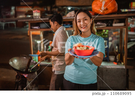 asian woman standing holding bowl of noodle asian woman standing holding bowl of noodle 110689095