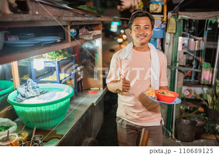 asian male seller holding noodle bowl thumb up gesture 110689125