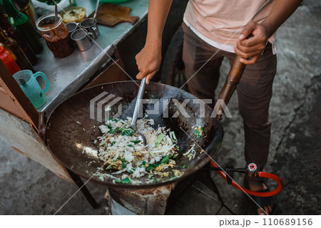 male hand stirring indonesian fried rice in the wok 110689156