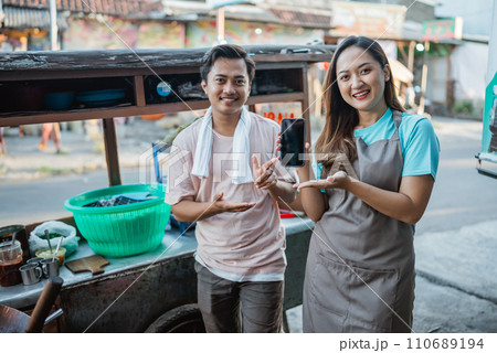 indonesian seller couple holding mockup phone 110689194