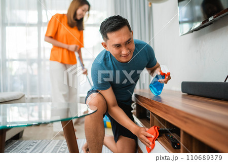 asian man holding rag wiping table asian man holding rag wiping table 110689379