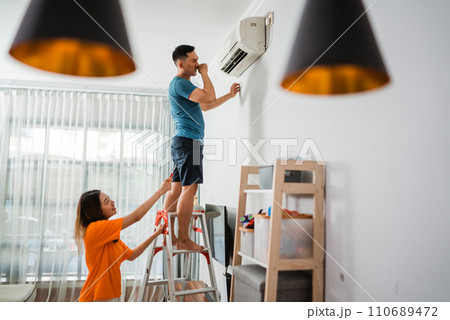 asian man climbing up stairs to fixing airconditioner asian man climbing up stairs to fixing airconditioner 110689472
