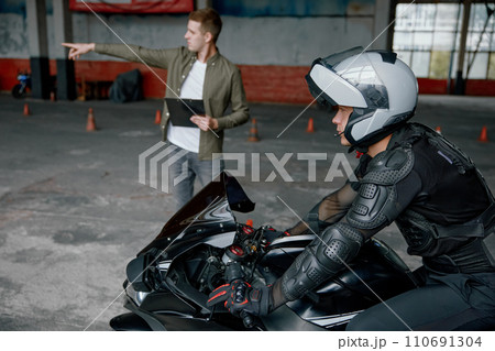 Driving practice at motorcycle driver training center with indoor motordrome Driving practice at motorcycle driver training center with indoor motordrome 110691304