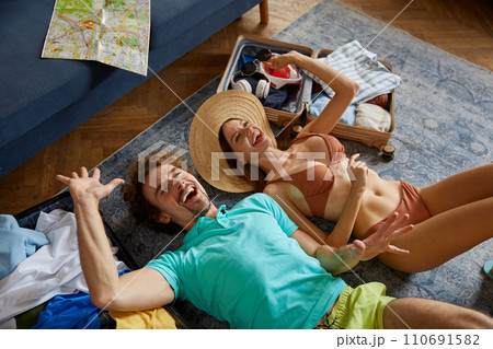 Happy couple in summer clothing celebrating start of vacation time Happy couple in summer clothing celebrating start of vacation time 110691582
