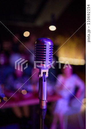Retro microphone on stage in a pub or American Bar restaurant during a night show. Retro microphone on stage in a pub or American Bar restaurant during a night show. 110692154