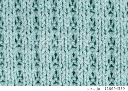 Texture and background of knitted turquoise sweater made of synthetic fabric. 110694589