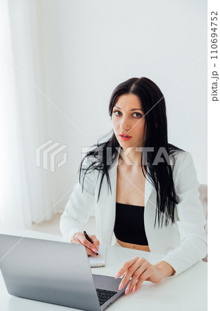 Woman in white business suit working on laptop small business online office 110694752