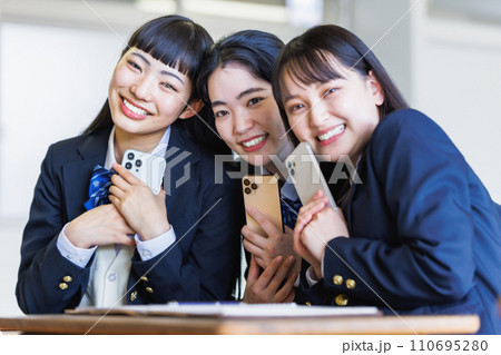 教室でスマホを見せあう女子高生 110695280