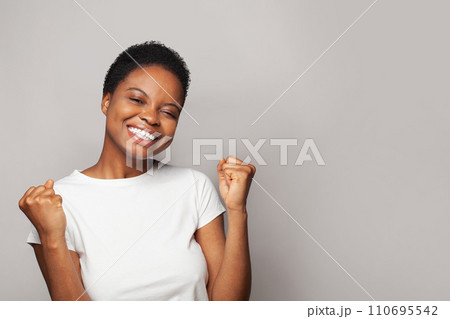 Surprised happy woman smiling and having fun against white studio wall background Surprised happy woman smiling and having fun against white studio wall background 110695542