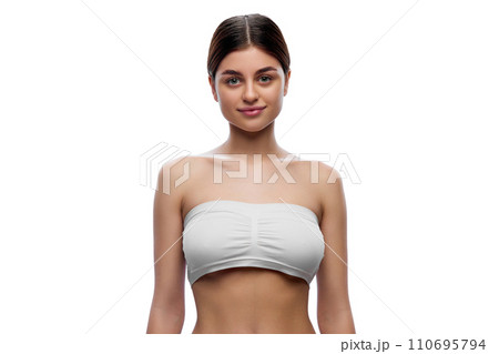 Half-length portrait of young attractive woman in white underwear posing looking at camera against white studio background. Half-length portrait of young attractive woman in white underwear posing looking at camera against white studio background. 110695794