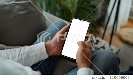AI-generated content. Person Sitting on Couch Holding Blank Cell Phone 110696002