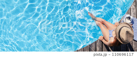 Woman on wooden deck near swimming pool 110696117