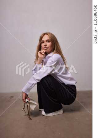 High fashion photo of a beautiful elegant young woman in a pretty beige suit 110696450
