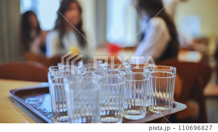 Glass tumblers in the school cafeteria. 110696827