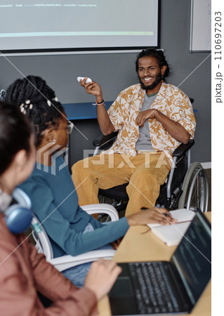 Man with disability in stylish outfit giving presentation to his colleagues at business conference 110697203
