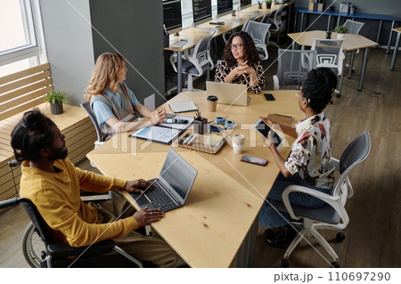 Group of multi-ethnic colleagues having business meeting at desk in modern urban office Group of multi-ethnic colleagues having business meeting at desk in modern urban office 110697290