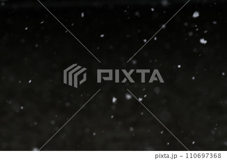 Bokeh of white snow on a black background. Snowfall - design element. Bokeh of white snow on a black background. Snowfall - design element. 110697368