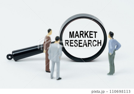 On a white background, figures of businessmen and a magnifying glass with the inscription - Market Research 110698113