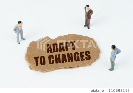 On a white background, figures of businessmen and torn cardboard with the inscription - Adapt to Changes On a white background, figures of businessmen and torn cardboard with the inscription - Adapt to Changes 110698115