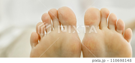 Two feet of a woman pressed against each other. Toes close-up, foot partially visible. Two feet of a woman pressed against each other. Toes close-up, foot partially visible. 110698148