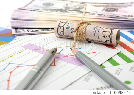 Business accessory, graph charts and pencil and dollars on the table. Business accessory, graph charts and pencil and dollars on the table. 110698272