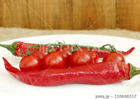 cherry tomatoes and pods of chili peppers cherry tomatoes and pods of chili peppers 110698317