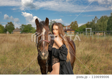Beautiful caucasian woman in black bodysuit with horse 110699006