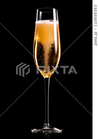 A crystal-clear flute glass of champagne isolated on black background 110699363