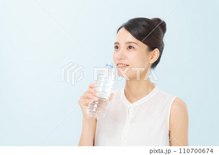 ペットボトルの水を飲む女性 110700674
