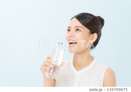 ペットボトルの水を飲む女性 110700675