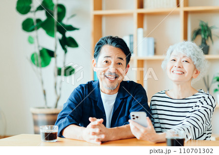 一緒にスマホを見ているシニア夫婦。 110701302