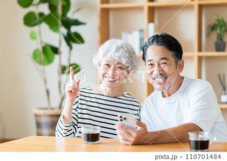 一緒にスマホを見ているシニア夫婦。 110701484
