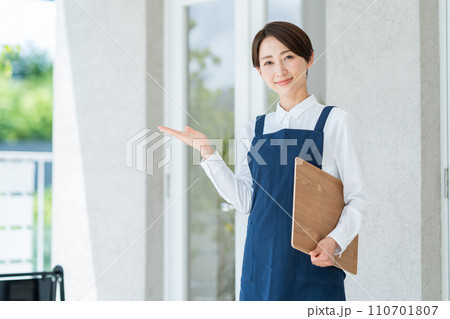 カフェの店内に案内する女性 110701807