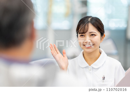 患者に説明をする医療従事者の女性。 患者に説明をする医療従事者の女性。 110702016