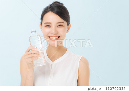ペットボトルの水を飲む女性 110702333
