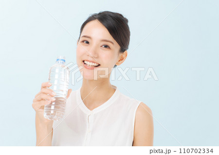 ペットボトルの水を飲む女性 110702334
