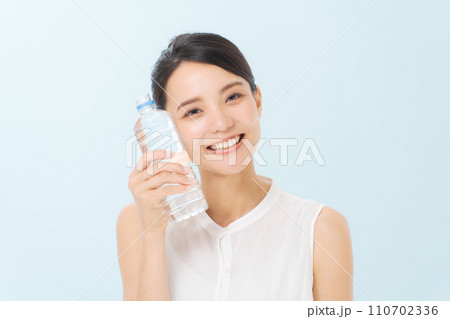 ペットボトルの水を飲む女性 110702336