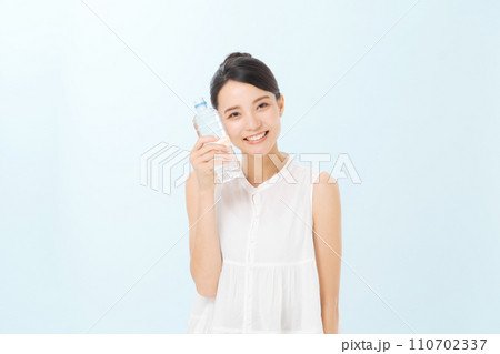 ペットボトルの水を飲む女性 110702337