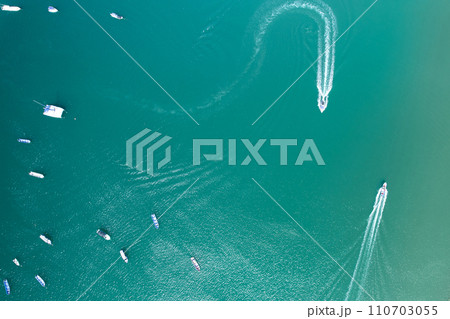 Small boats moving in blue sea water 110703055