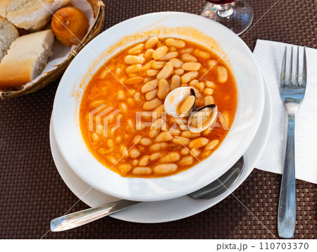 Top view of plate of beans stewed with clams. 110703370