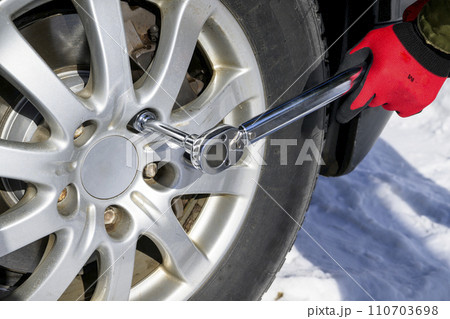タイヤのナットをトルクレンチで締める男性 110703698