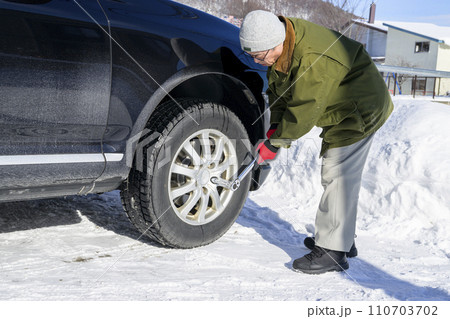 タイヤのナットをトルクレンチで締める男性 110703702