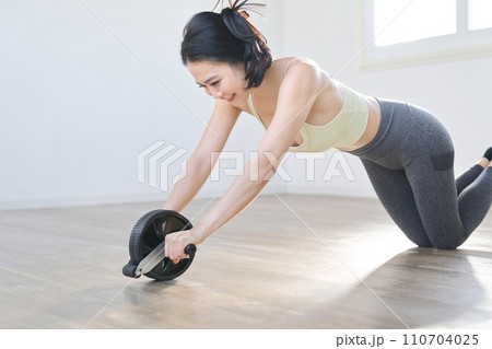 アブローラーで腹筋を鍛える女性 110704025