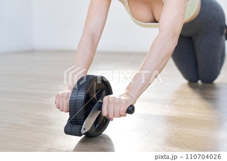 アブローラーで腹筋を鍛える女性 アブローラーで腹筋を鍛える女性 110704026