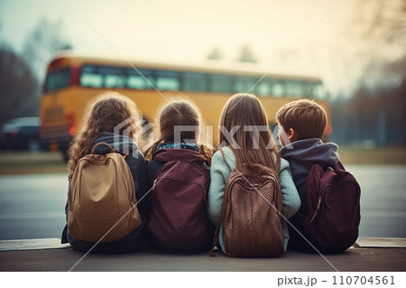 Back view of group of schoolchildren classmates with backpack sitting and waiting for get onto school bus. Back to school concept. Generative AI. 110704561